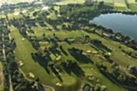 Blick auf Platz Rot mit verschiedenen Spielbahnen, Bäumen und Baggersee auf rechter Seite