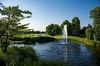 Wasserfontäne im Golfteich mit Schilf am Wasserrand